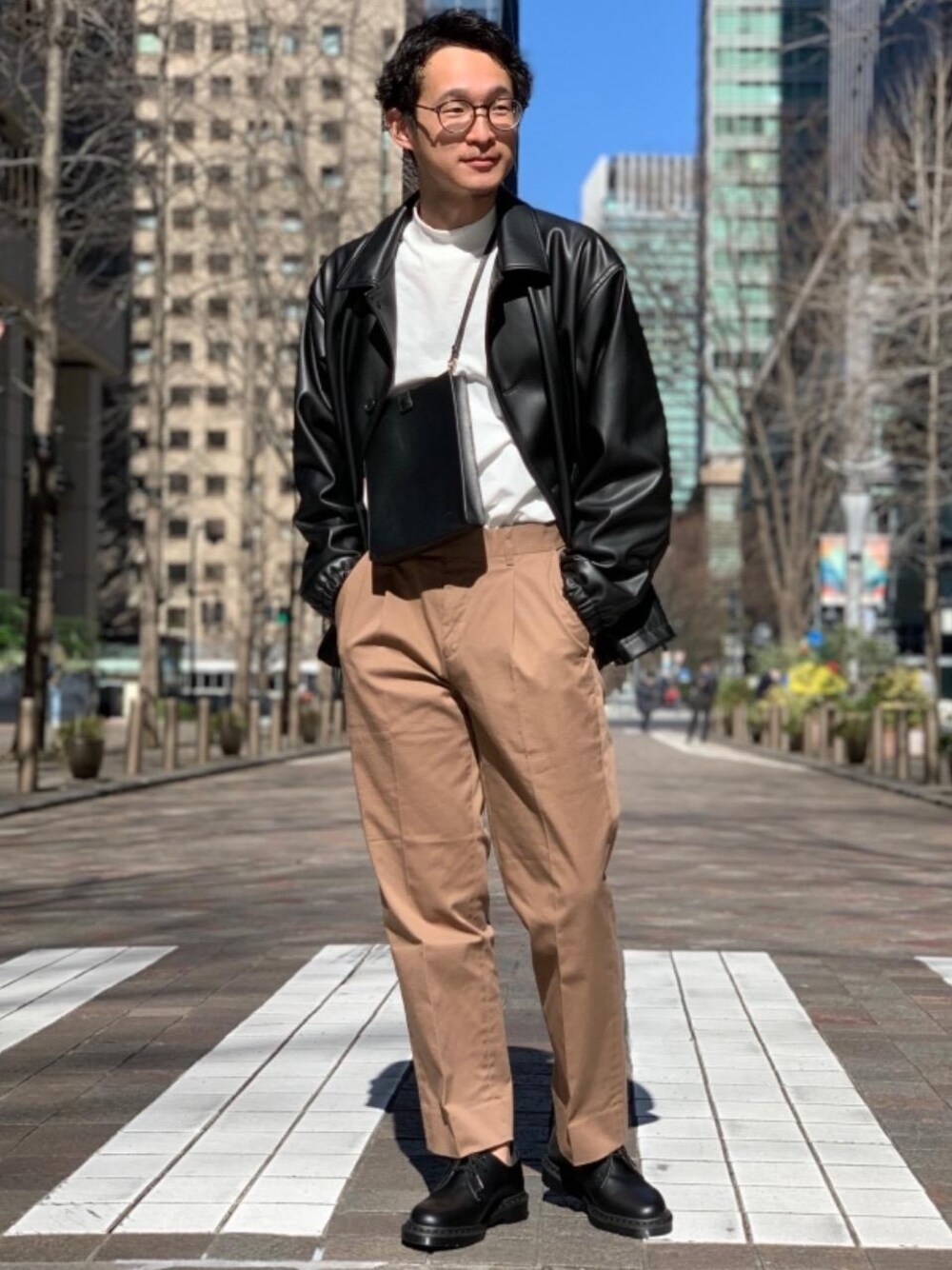 ブラック系のその他シューズ、ブラック系のショルダーバッグ、ホワイト系のTシャツ/カットソーを着用したメンズの冬コーディネートの1枚目の写真