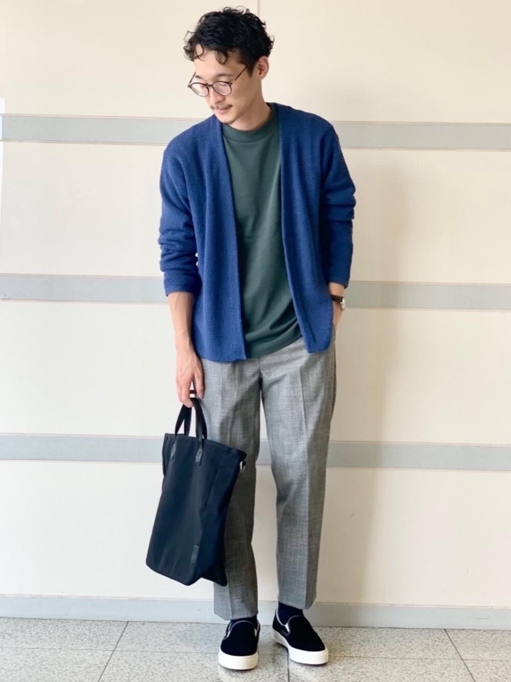 ブラック系のトートバッグ、ブラック系のスニーカー、グリーン系のTシャツ/カットソーを着用したメンズの秋コーディネートの1枚目の写真