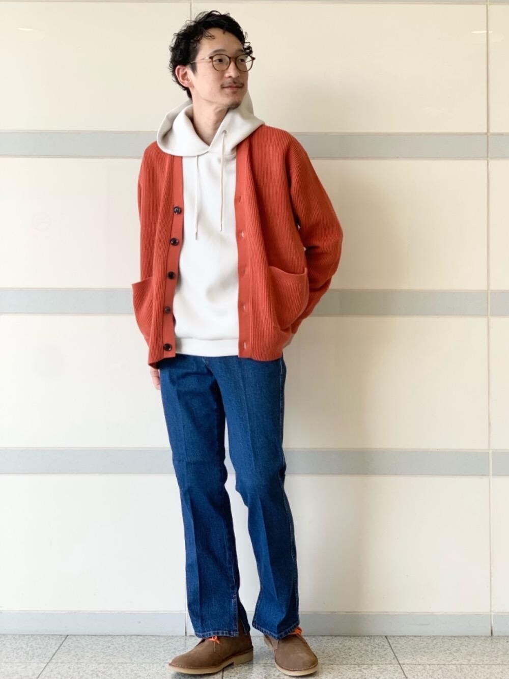 グレー系のパーカー、ブルー系のデニムパンツ、ベージュ系のブーツを着用したメンズの秋コーディネートの1枚目の写真