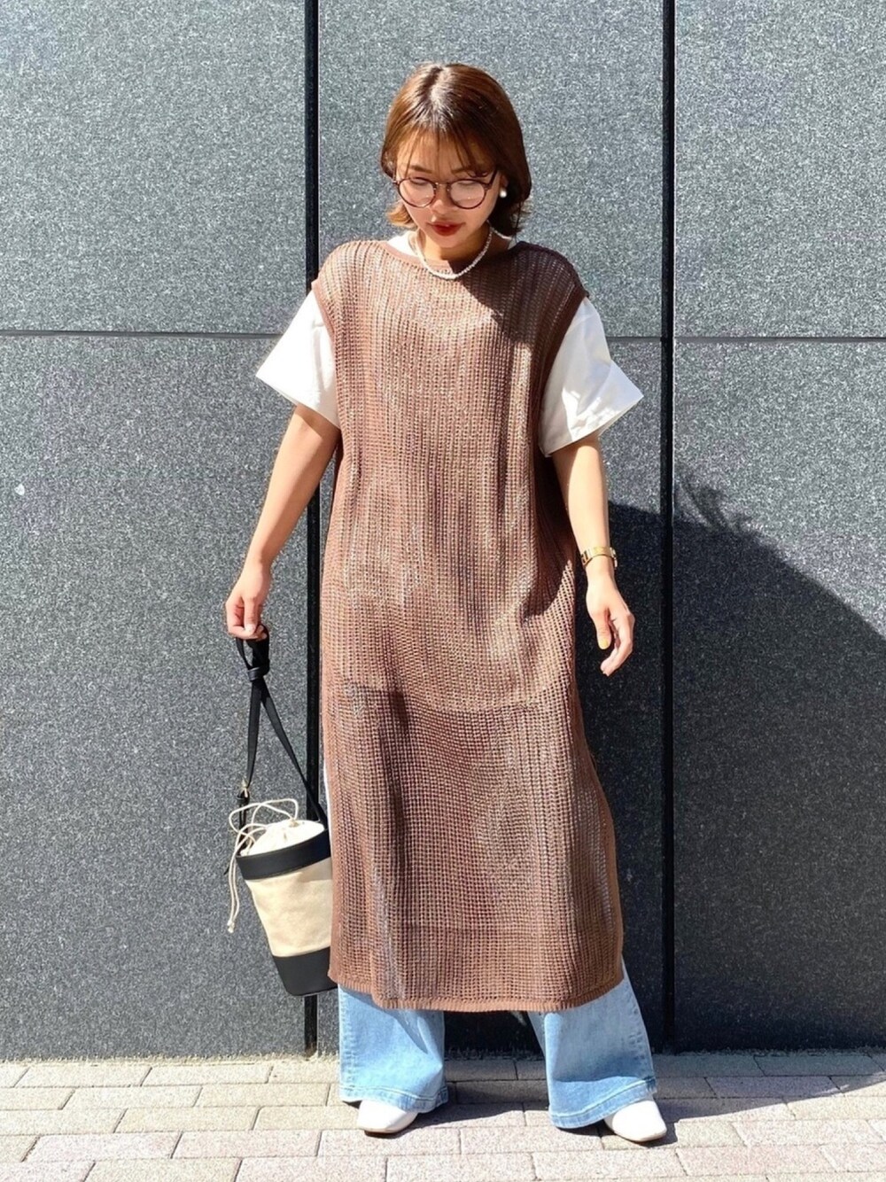 ブラウン系のワンピース、ホワイト系のTシャツ/カットソー、ブルー系のデニムパンツを着用したレディースの夏コーディネートの1枚目の写真