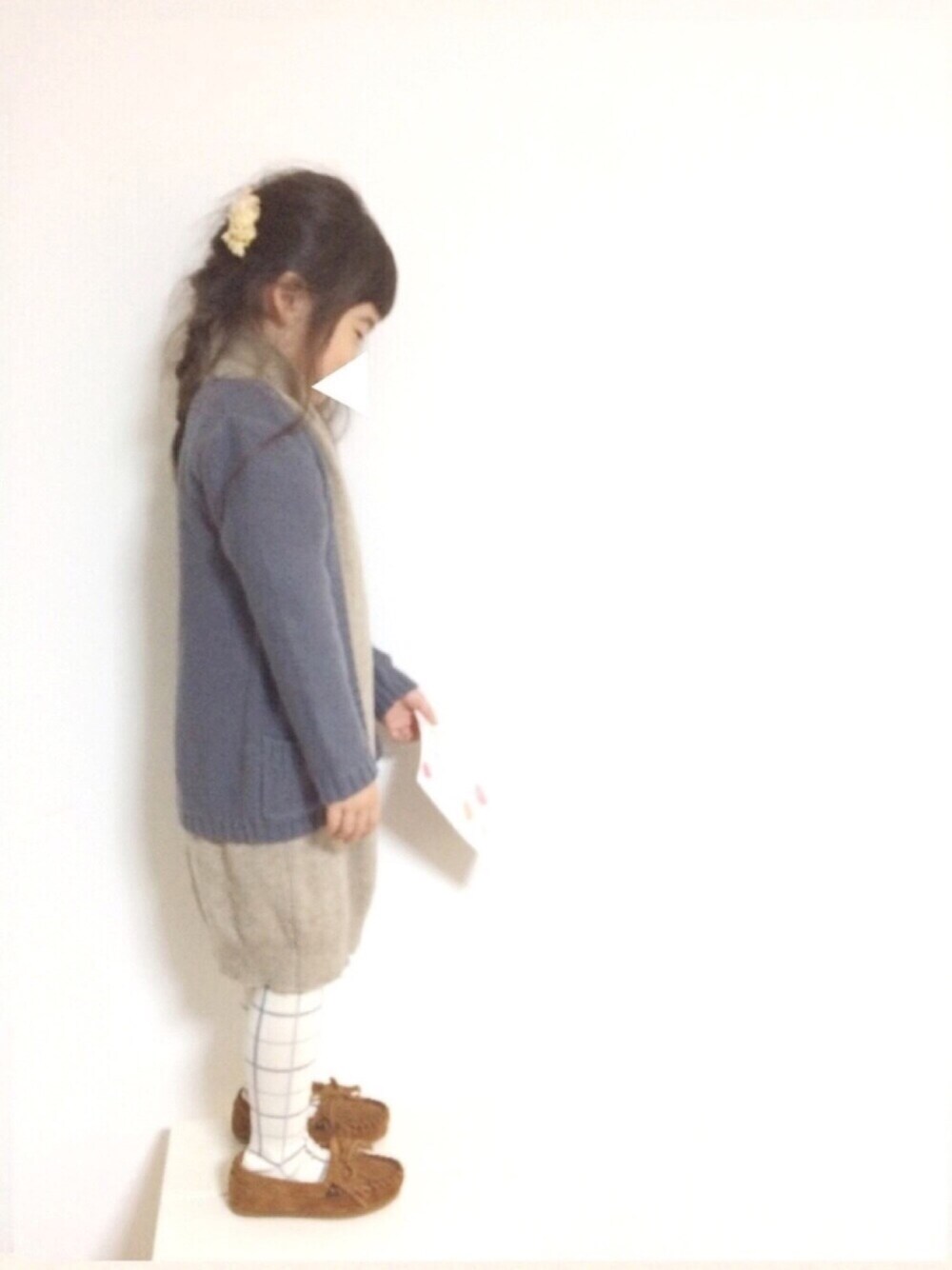 ベージュ系のワンピース、ブルー系のカーディガン/ボレロ、ベージュ系のヘアアクセサリーを着用したキッズの冬コーディネートの1枚目の写真