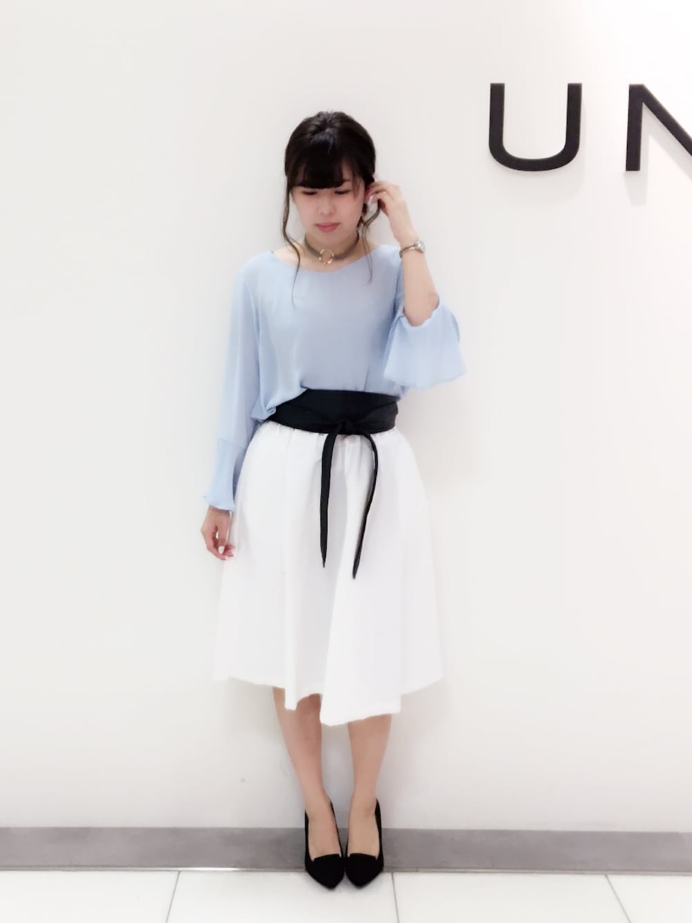 ホワイト系のスカート、ブルー系のシャツ/ブラウス、ブラック系のベルトを着用したレディースの春コーディネートの1枚目の写真