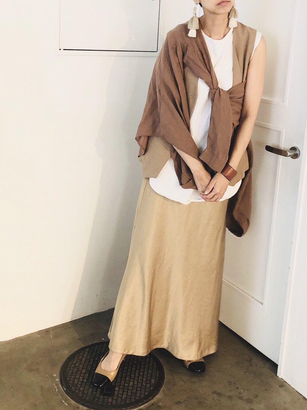 ブラウン系のシャツ/ブラウス、ホワイト系のTシャツ/カットソー、ベージュ系のベストを着用したレディースの秋コーディネートの1枚目の写真