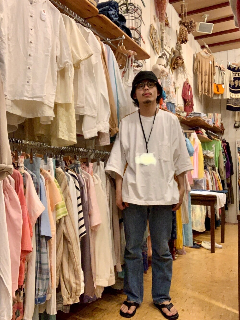 ホワイト系のTシャツ/カットソー、ブルー系のデニムパンツ、ブラック系のサンダルを着用したメンズの夏コーディネートの1枚目の写真