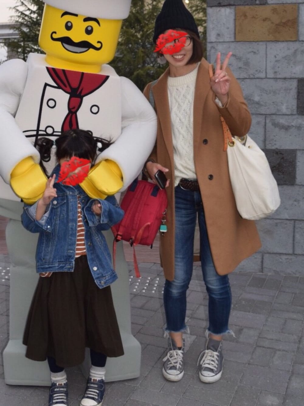 ブラウン系のチェスターコート、ホワイト系のショルダーバッグ、ブルー系のデニムパンツを着用したレディースの秋コーディネートの1枚目の写真