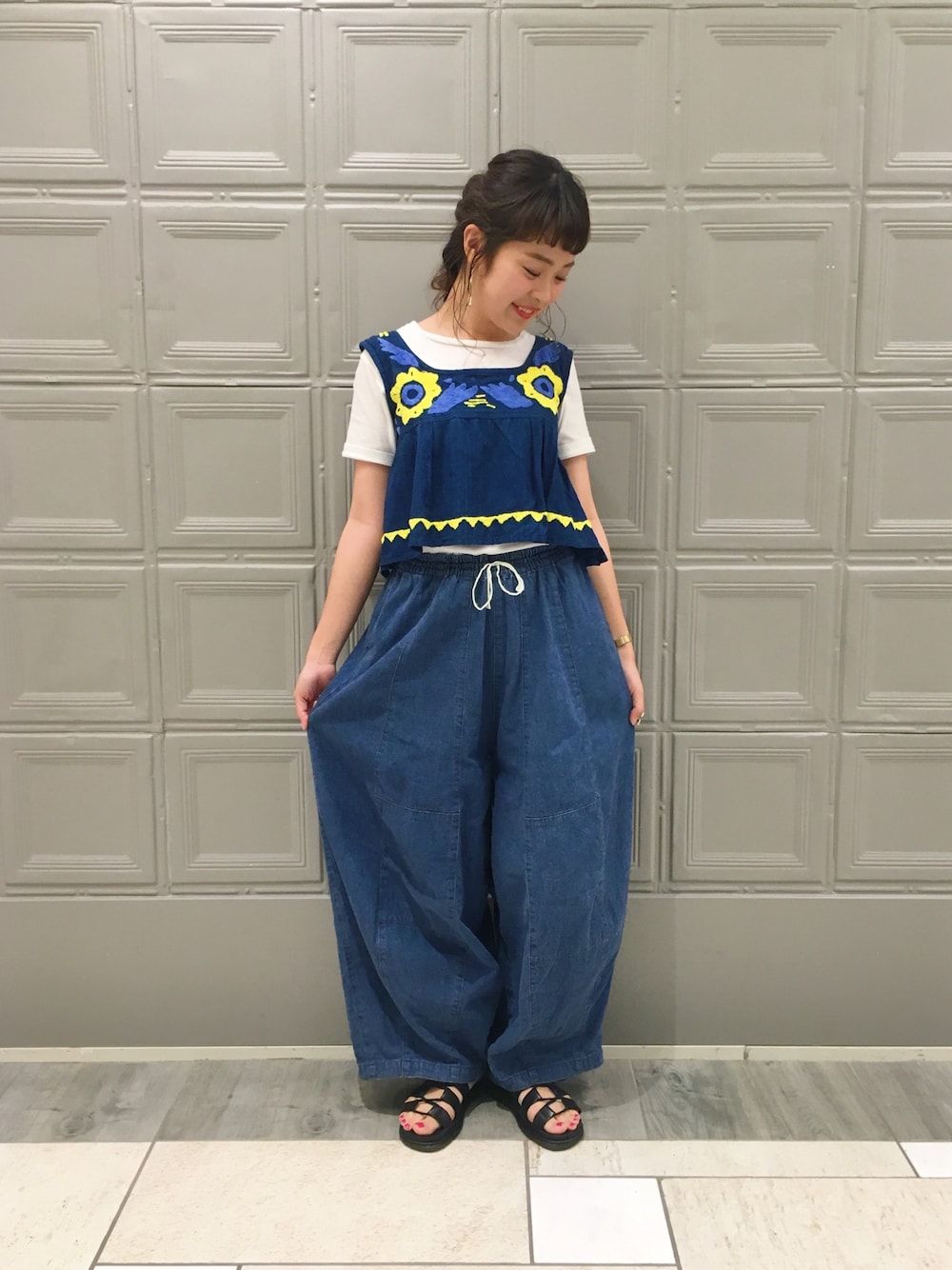 ブルー系のタンクトップ、ホワイト系のTシャツ/カットソー、ブルー系のパンツを着用したレディースの夏コーディネートの1枚目の写真