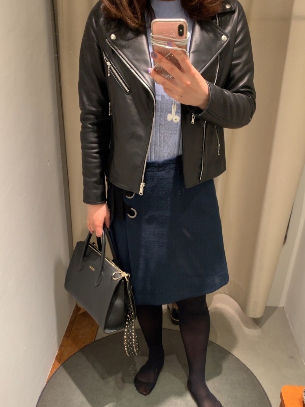 ブルー系のスカート、ブルー系のニット/セーター、ブラック系のバッグを着用したレディースの春コーディネートの1枚目の写真