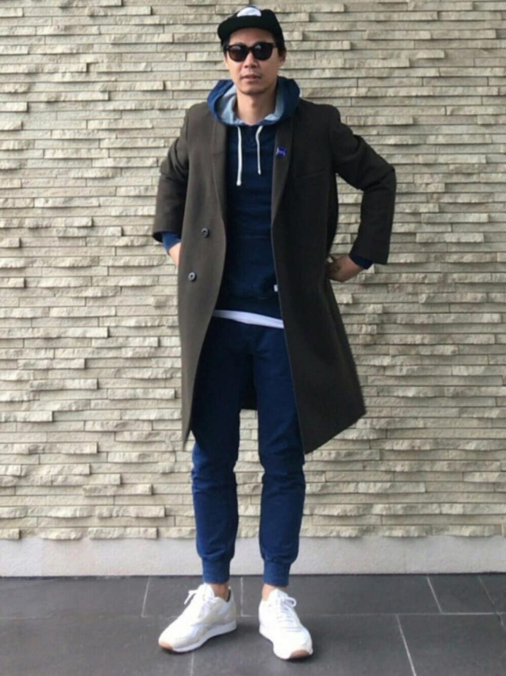 ホワイト系のスニーカー、ブルー系のパンツ、ブルー系のパーカーを着用したメンズの冬コーディネートの1枚目の写真