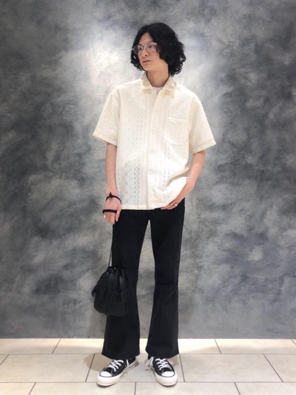 ブラック系のスニーカー、ホワイト系のTシャツ/カットソー、ブラック系のデニムパンツを着用したメンズの春コーディネートの1枚目の写真
