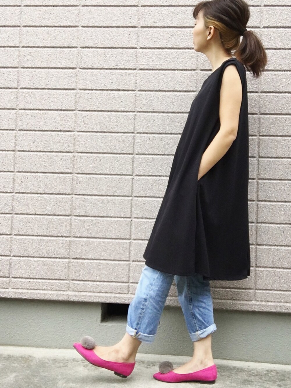 ブラック系のワンピース、ブルー系のデニムパンツ、ピンク系のシューズを着用したレディースの夏コーディネートの1枚目の写真