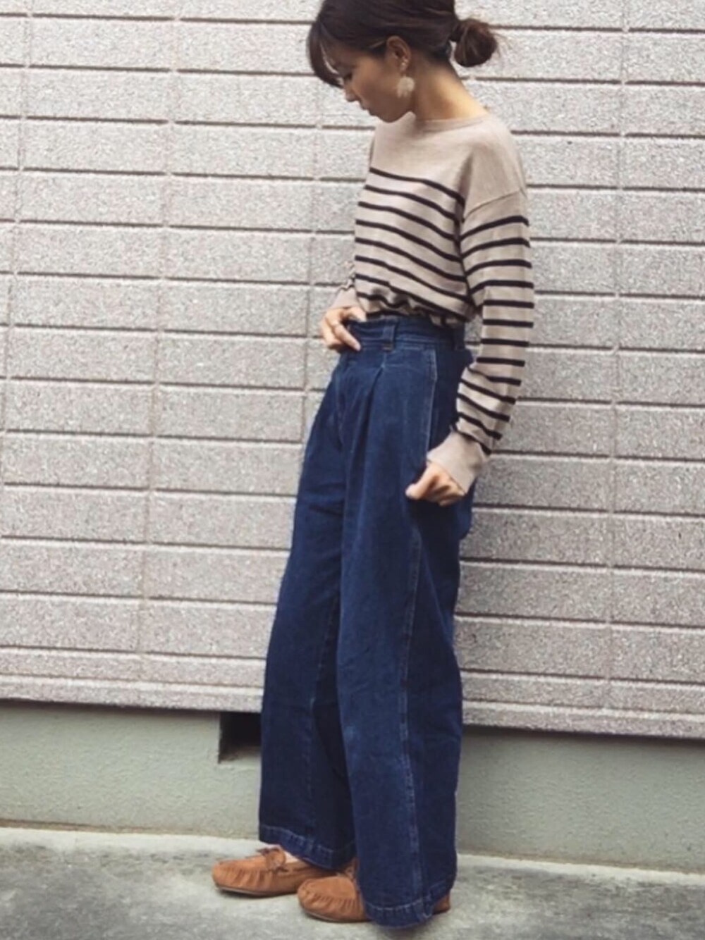 ベージュ系のニット/セーター、ブルー系のデニムパンツ、ブラウン系のモカシン/デッキシューズを着用したレディースの秋コーディネートの1枚目の写真