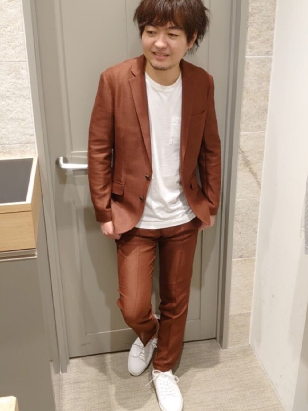 レッド系のテーラードジャケット、レッド系のスラックス、ホワイト系のスニーカーを着用したメンズの夏コーディネートの1枚目の写真