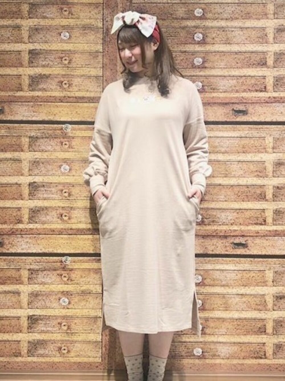 ベージュ系のワンピース、レッド系のヘアバンドを着用したレディースの春コーディネートの1枚目の写真