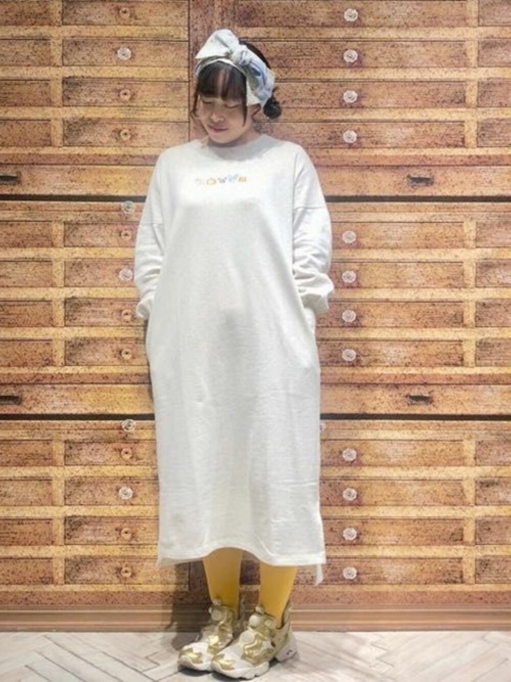 ベージュ系のワンピース、ホワイト系のヘアバンドを着用したレディースの春コーディネートの1枚目の写真