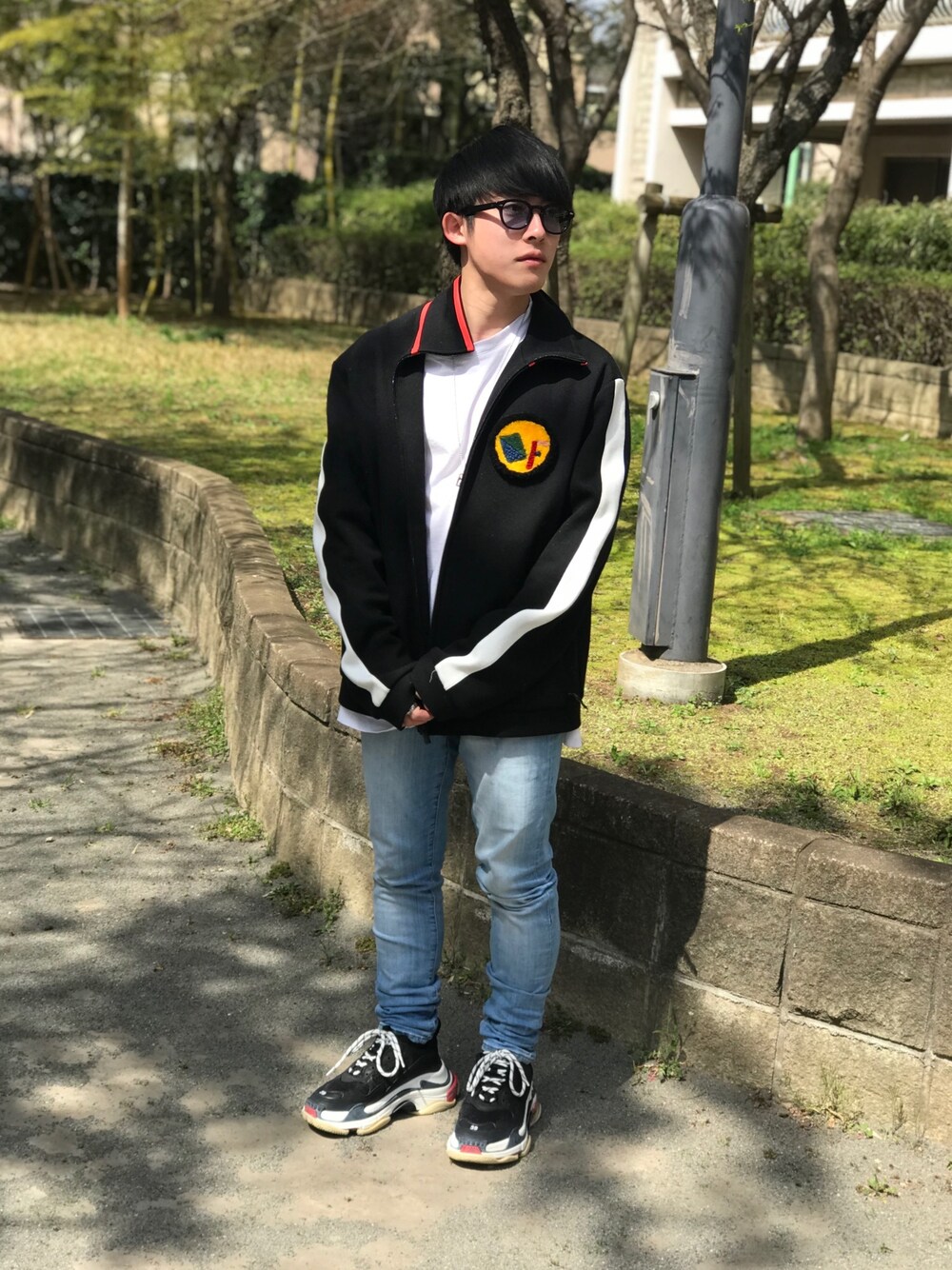 ブラック系のその他アウター、ブルー系のデニムパンツ、ブラック系のスニーカーを着用したメンズの春コーディネートの1枚目の写真