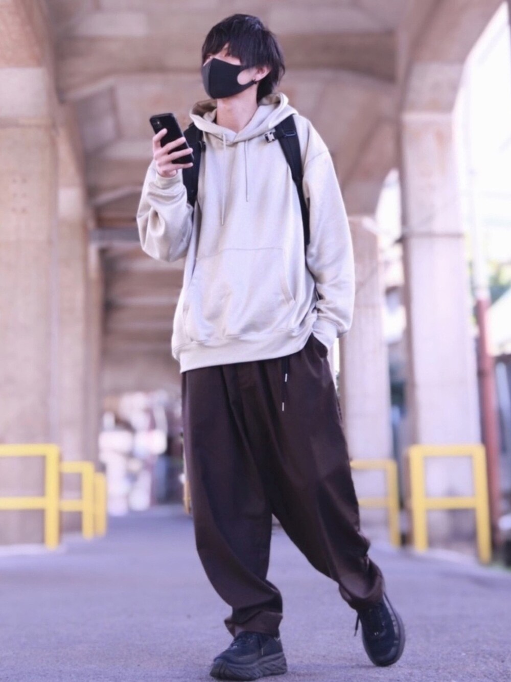 ホワイト系のパーカー、ブラウン系のその他パンツ、ブラック系のバックパック/リュックを着用したメンズの秋コーディネートの1枚目の写真