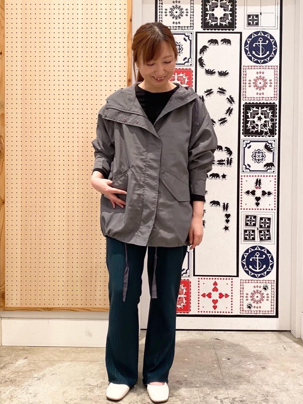 グレー系のマウンテンパーカー、ブラック系のTシャツ/カットソー、グリーン系のその他パンツを着用したレディースの春コーディネートの1枚目の写真