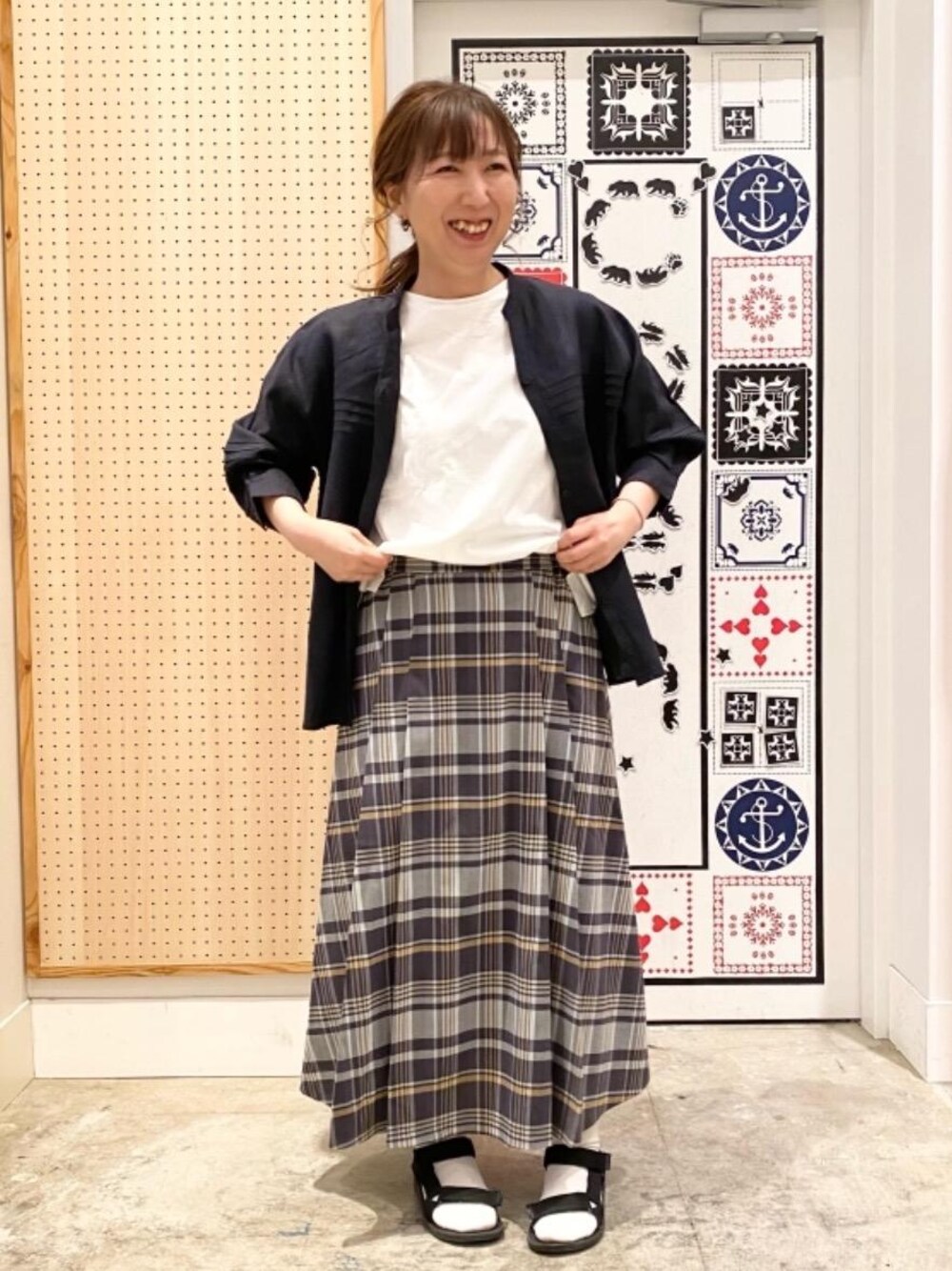 ブラック系のシャツ/ブラウス、グレー系のスカート、ホワイト系のTシャツ/カットソーを着用したレディースの春コーディネートの1枚目の写真