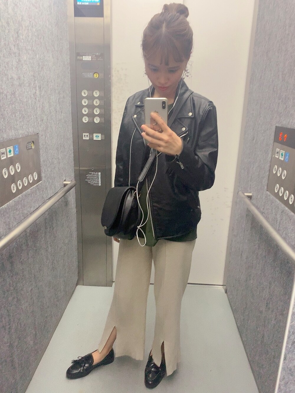 ブラック系のライダースジャケット、グリーン系のシャツ/ブラウス、ブラック系のショルダーバッグを着用したレディースの秋コーディネートの1枚目の写真