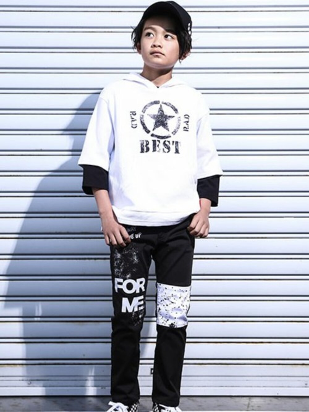 ブラック系のTシャツ/カットソー、ホワイト系のチノパンツ、ホワイト系のスニーカーを着用したキッズの春コーディネートの1枚目の写真