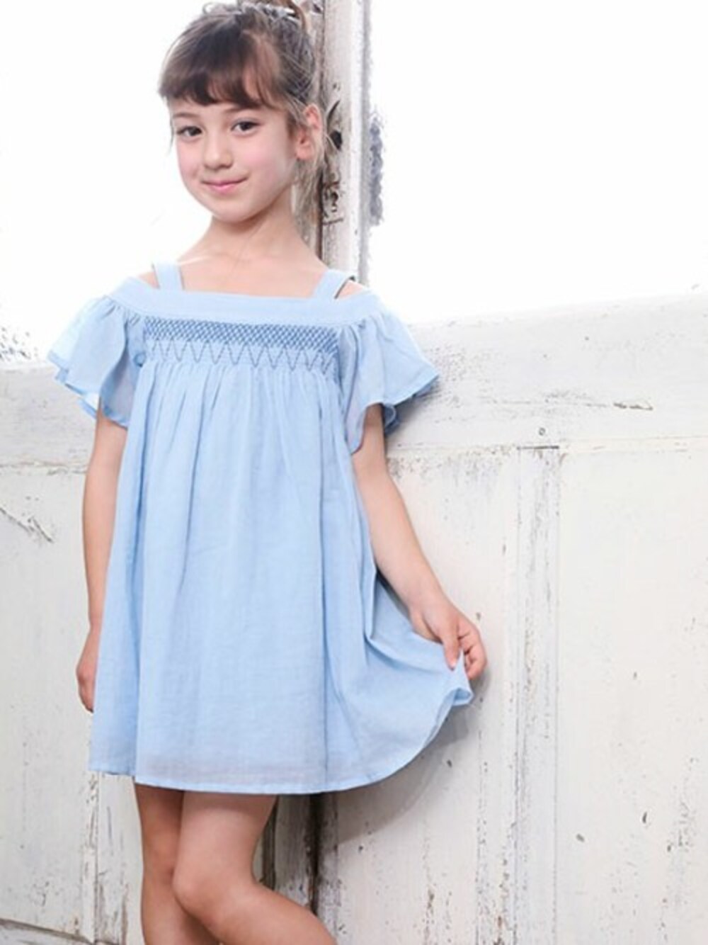パープル系のワンピース、グレー系のサンダル、ピンク系のヘアゴムを着用したキッズの夏コーディネートの1枚目の写真