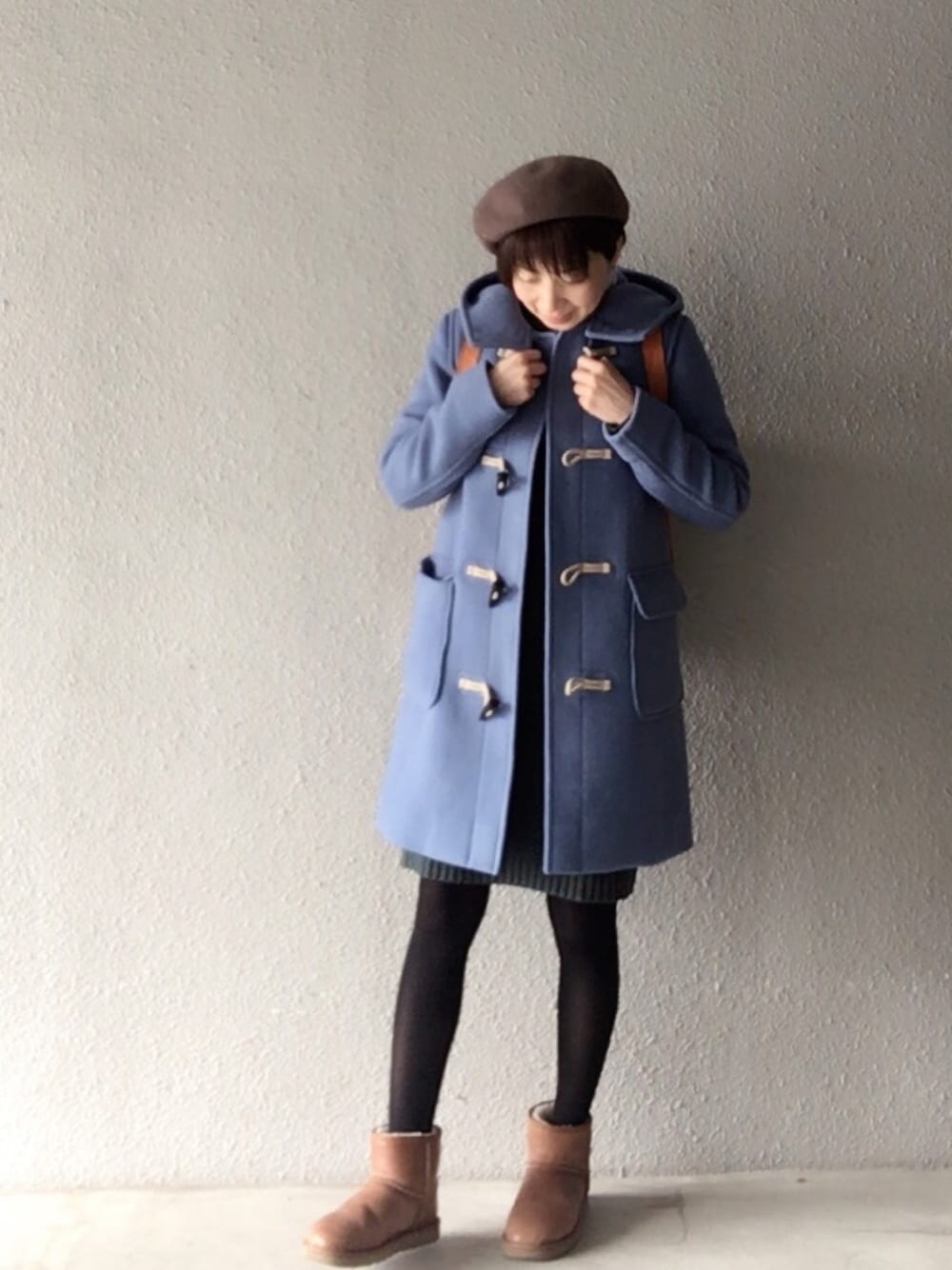 ブルー系のダッフルコート、グリーン系のワンピース、ブラウン系のバックパック/リュックを着用したレディースの春コーディネートの1枚目の写真