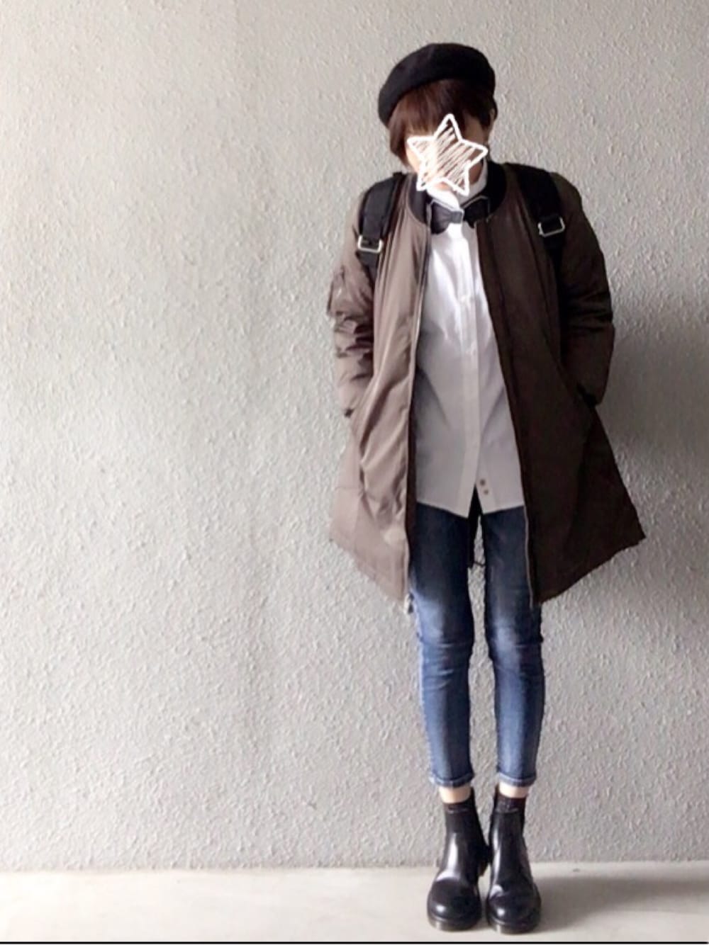 グリーン系のダウンジャケット/コート、ホワイト系のシャツ/ブラウス、ブルー系のデニムパンツを着用したレディースの春コーディネートの1枚目の写真