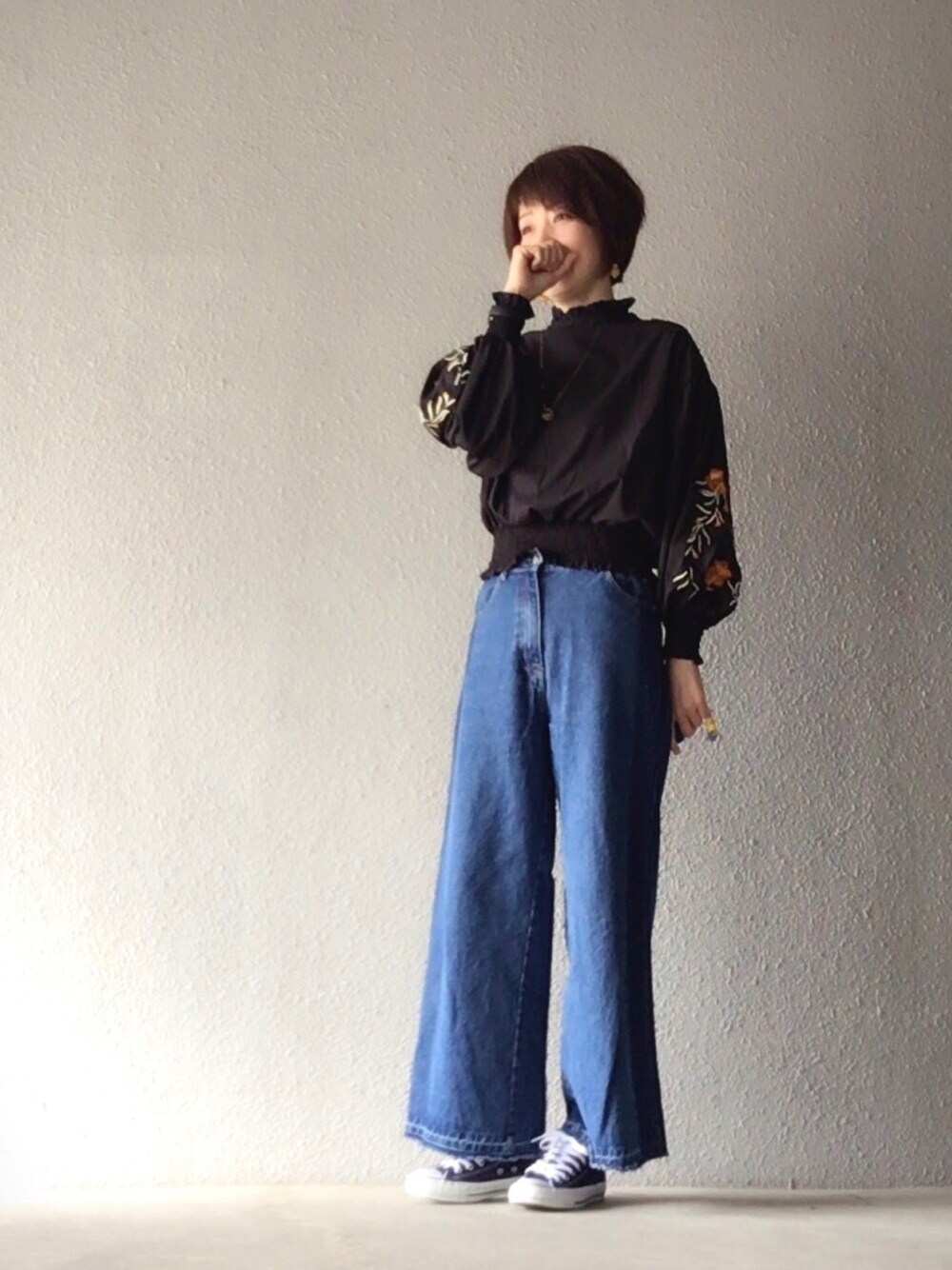 ブラック系のシャツ/ブラウス、ブルー系のスニーカー、ブラウン系のバックパック/リュックを着用したレディースの春コーディネートの1枚目の写真