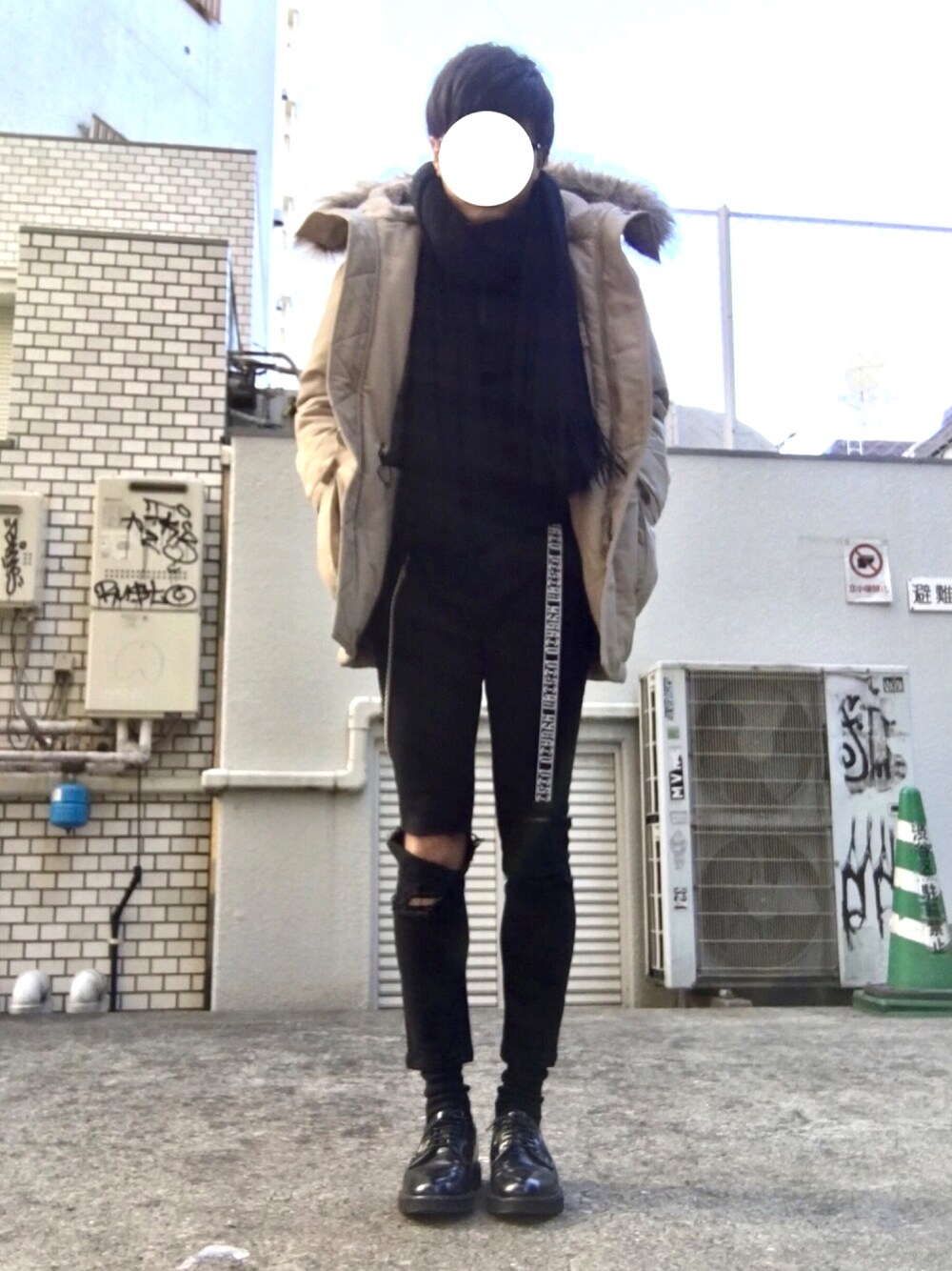 ブラック系のドレスシューズ、ブラック系のニット/セーター、ベージュ系のダウンジャケット/コートを着用したメンズの冬コーディネートの1枚目の写真