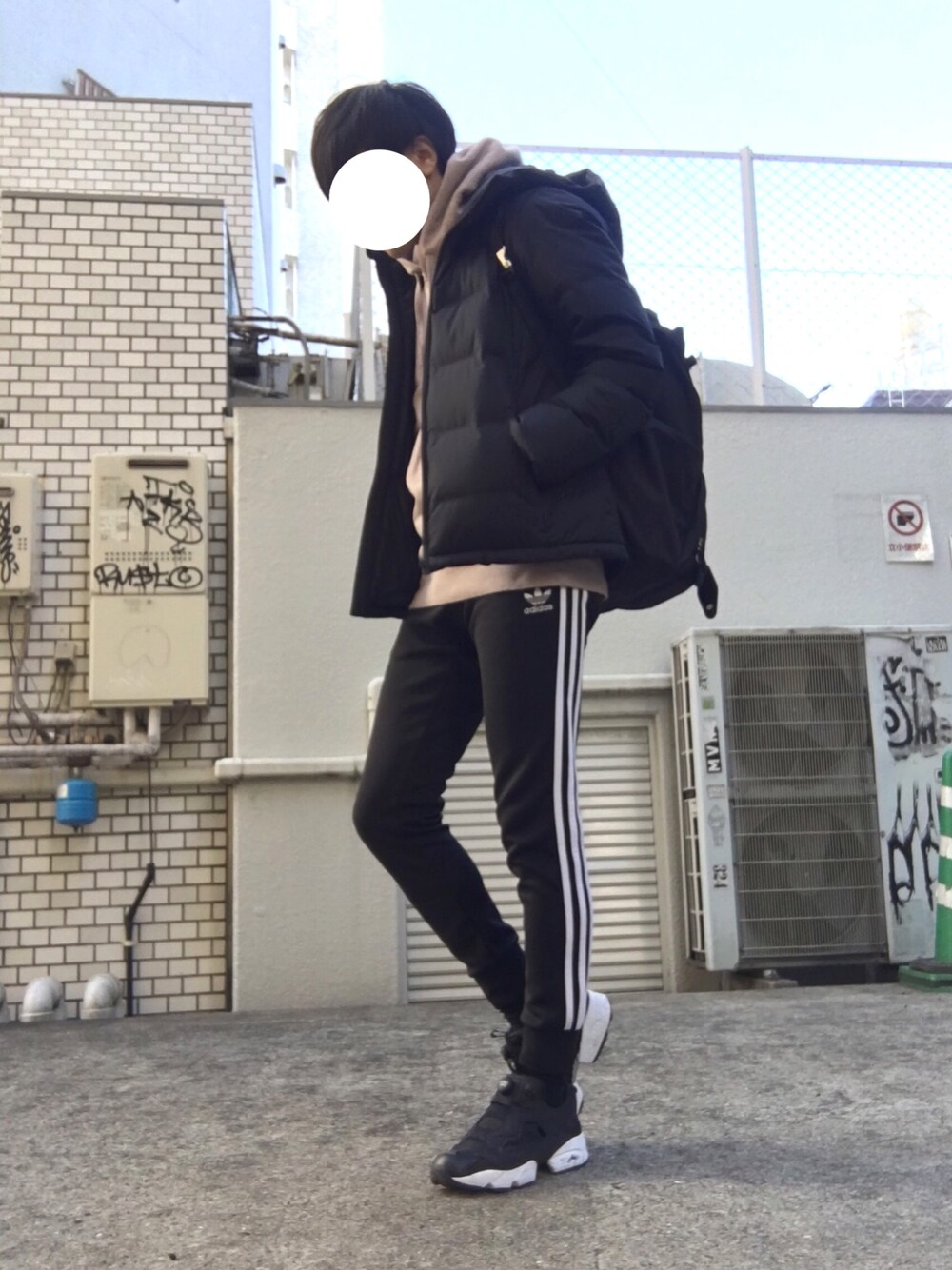 ブラック系のスニーカー、ブラック系のその他パンツ、ピンク系のパーカーを着用したメンズの冬コーディネートの1枚目の写真