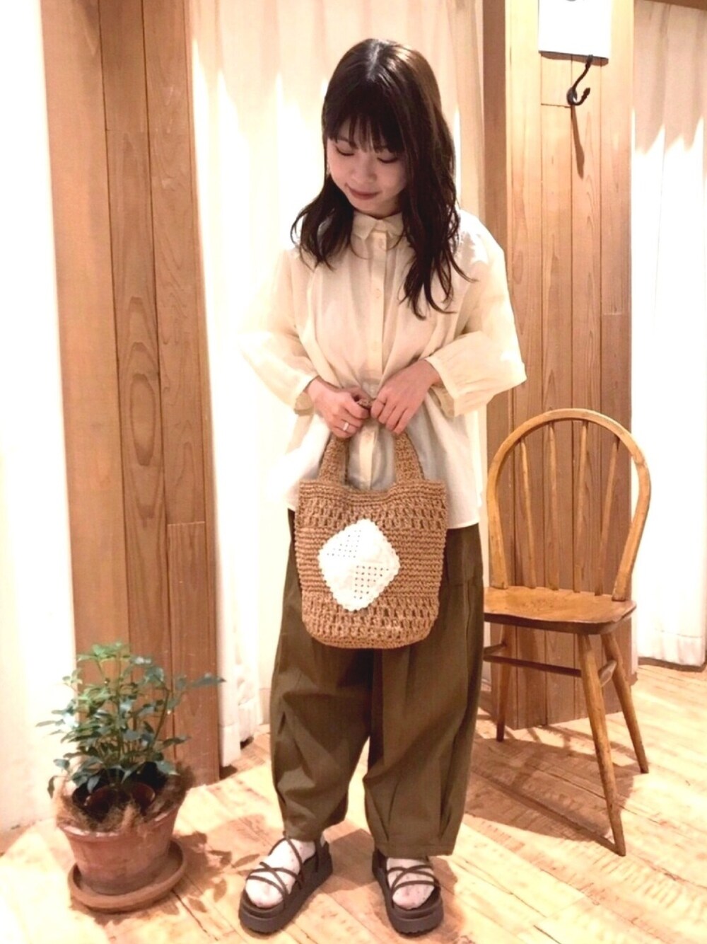 ベージュ系のトートバッグ、グリーン系のカーゴパンツ、ベージュ系のトップスを着用したレディースの春コーディネートの1枚目の写真