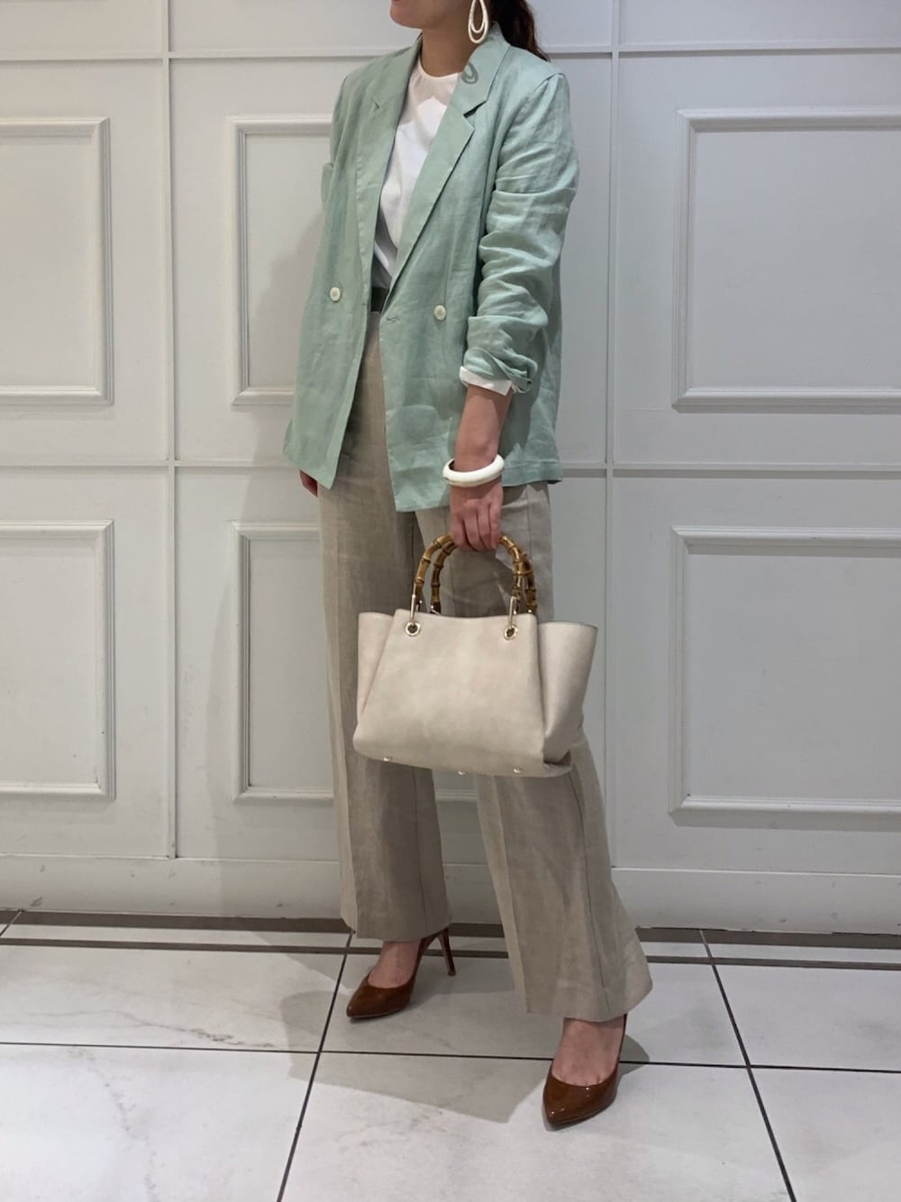 ベージュ系のその他パンツ、グリーン系のテーラードジャケット、ホワイト系のシャツ/ブラウスを着用したレディースの春コーディネートの1枚目の写真