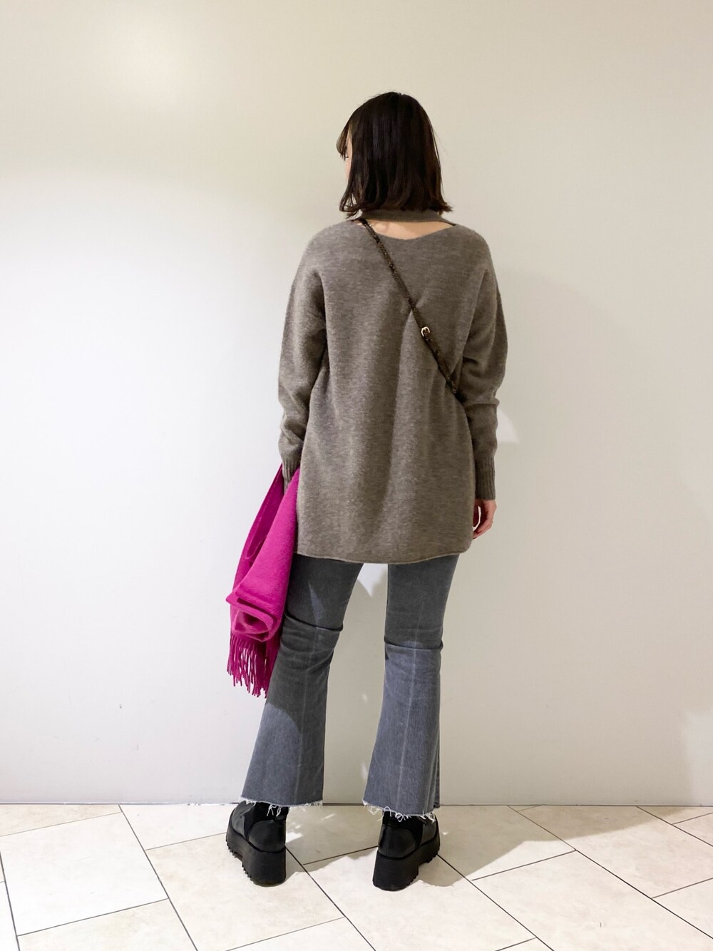 ブラウン系のニット/セーター、グレー系のデニムパンツ、ブラック系のブーツを着用したレディースの冬コーディネートの1枚目の写真