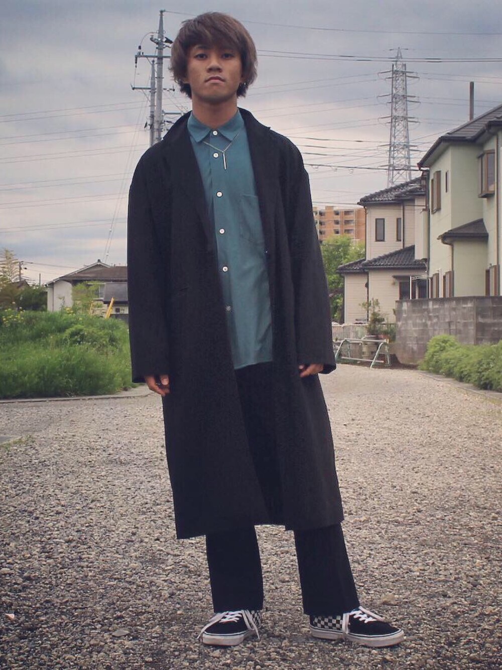 ブラック系のチェスターコート、グリーン系のシャツ/ブラウス、ブラック系のその他パンツを着用したメンズの春コーディネートの1枚目の写真