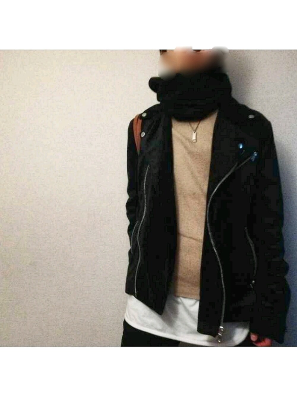 ブラック系のライダースジャケット、ベージュ系のニット/セーター、ホワイト系のタンクトップを着用したメンズの冬コーディネートの1枚目の写真
