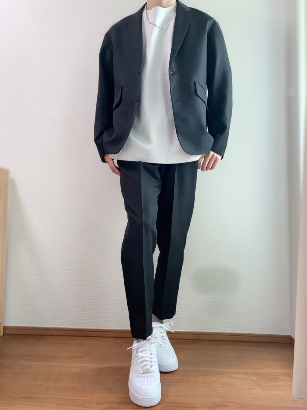 ブラック系のセットアップ、グレー系のTシャツ/カットソー、ホワイト系のスニーカーを着用したメンズの春コーディネートの1枚目の写真