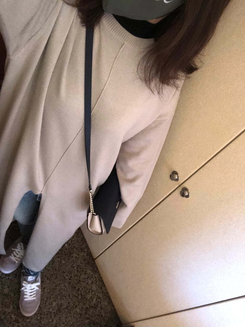 ブルー系のデニムパンツ、グレー系のスニーカーを着用したレディースの春コーディネートの1枚目の写真