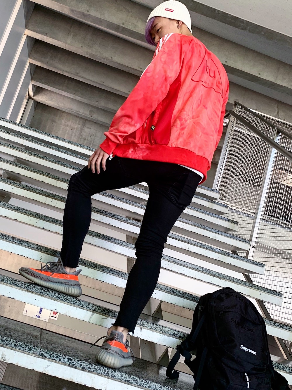 ブラック系のパンツ、レッド系のジャケット/アウター、グレー系のスニーカーを着用したメンズの秋コーディネートの1枚目の写真