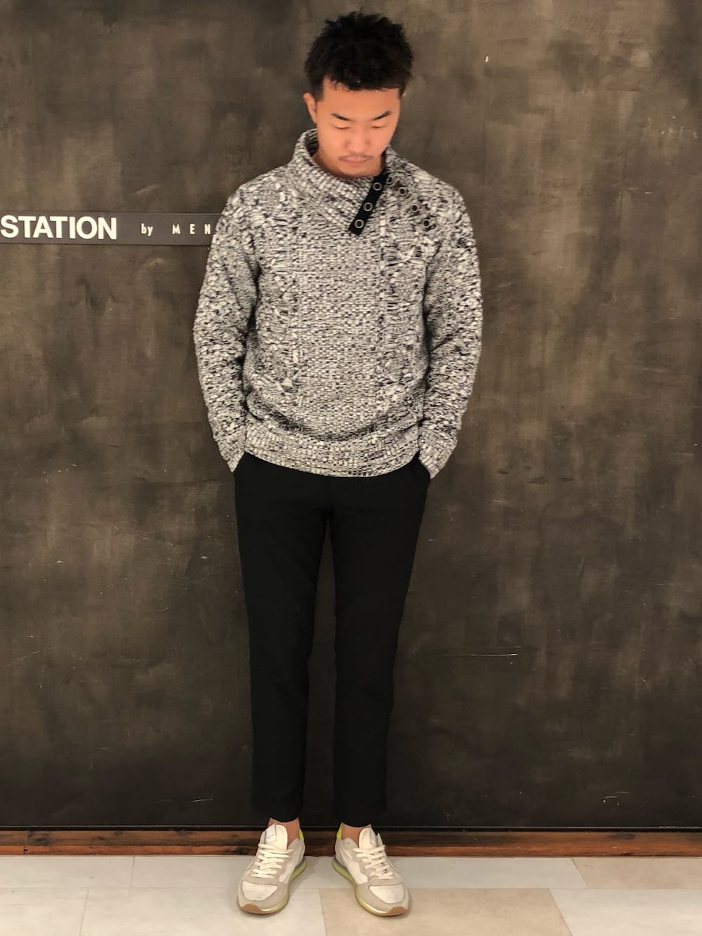 グレー系のニット/セーター、ブラック系のスラックスを着用したメンズの秋コーディネートの1枚目の写真