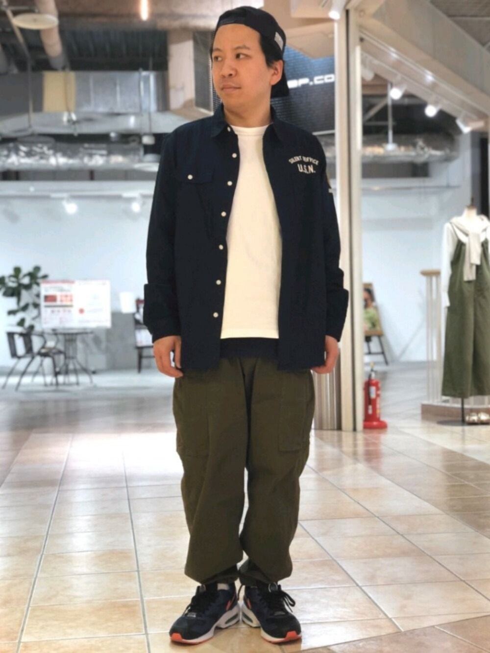 ブルー系のシャツ/ブラウス、グリーン系のカーゴパンツ、ブルー系のキャップを着用したメンズの春コーディネートの1枚目の写真