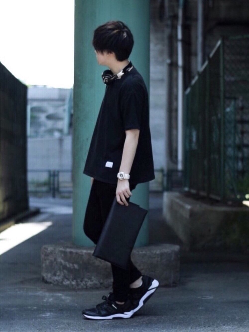 ブラック系のスニーカー、ブラック系のクラッチバッグ、ブラック系のその他パンツを着用したメンズの春コーディネートの1枚目の写真