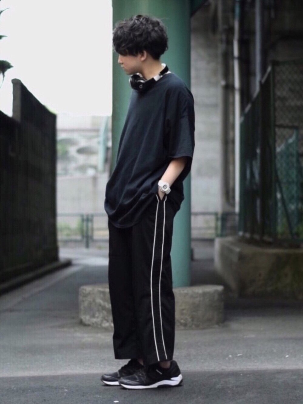 ブラック系のスラックス、ブラック系のTシャツ/カットソー、ブラック系のスニーカーを着用したメンズの夏コーディネートの1枚目の写真