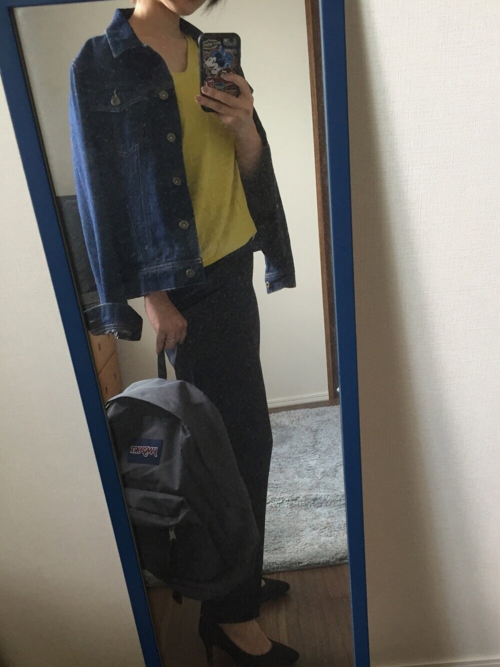 ブラック系のスラックス、グレー系のバックパック/リュック、イエロー系のTシャツ/カットソーを着用したレディースの秋コーディネートの1枚目の写真