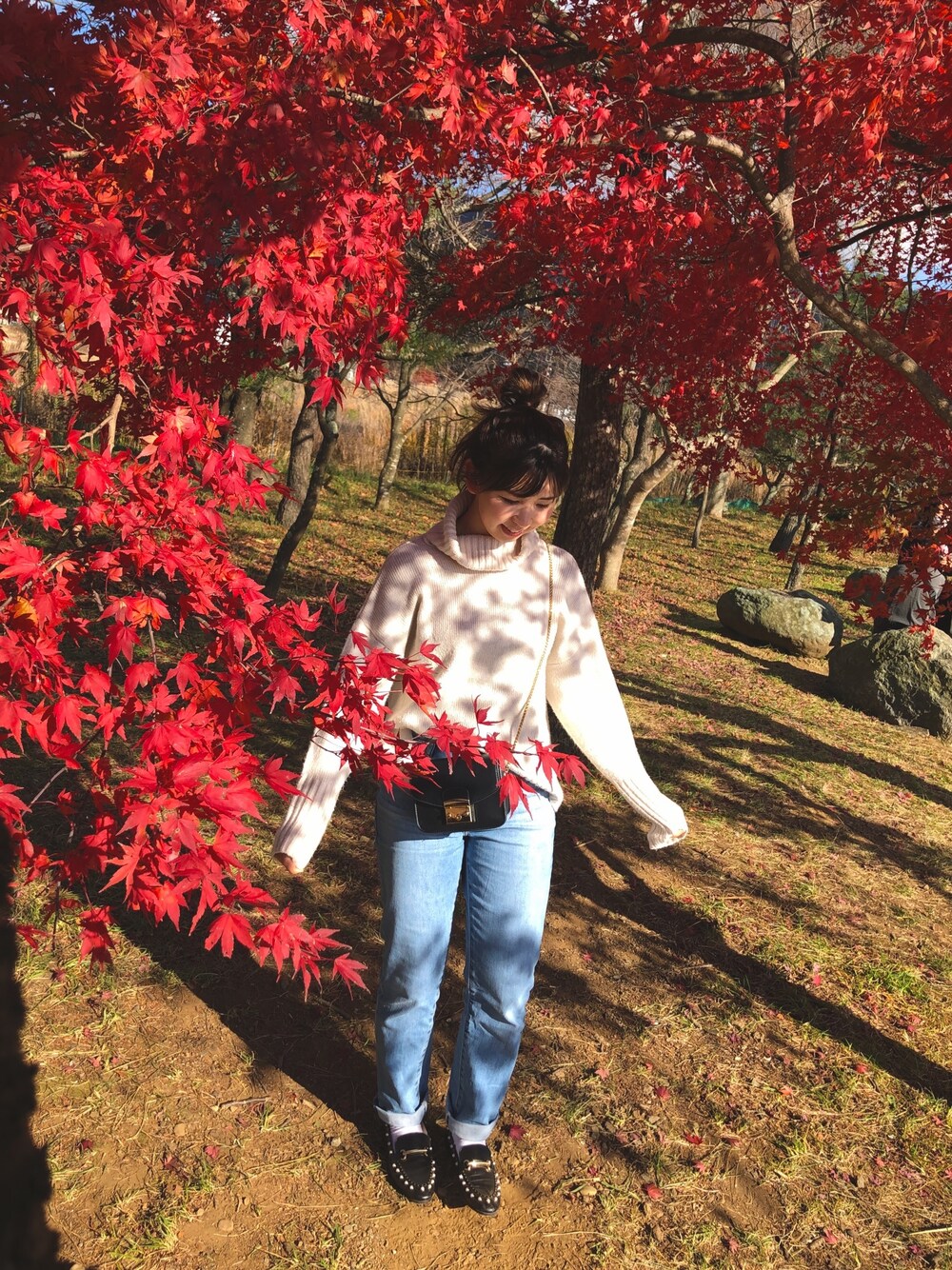 ホワイト系のニット/セーター、ブルー系のデニムパンツ、ブラック系のローファーを着用したレディースの秋コーディネートの1枚目の写真