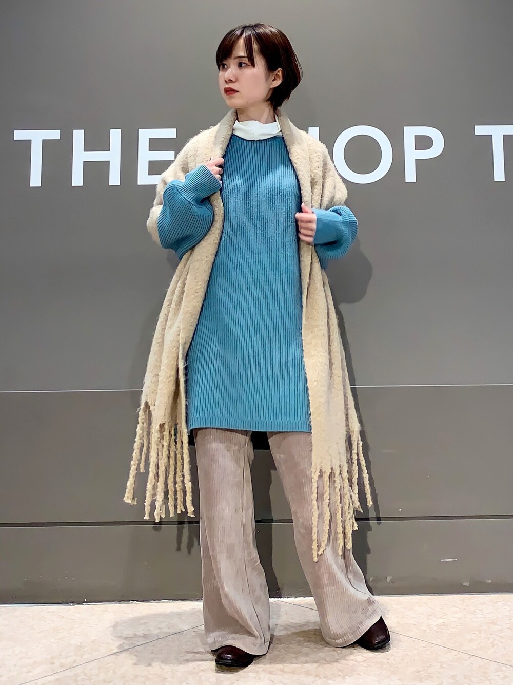 グリーン系のニット/セーター、ベージュ系のその他パンツ、ブラウン系のブーツを着用したレディースの冬コーディネートの1枚目の写真