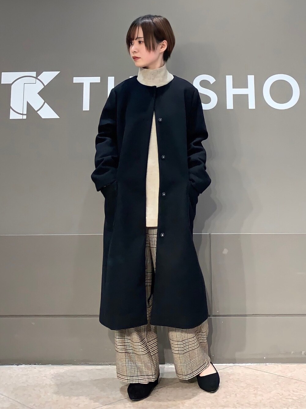 ベージュ系のニット/セーター、ブラウン系のその他パンツ、ブラック系のノーカラーコートを着用したレディースの冬コーディネートの1枚目の写真