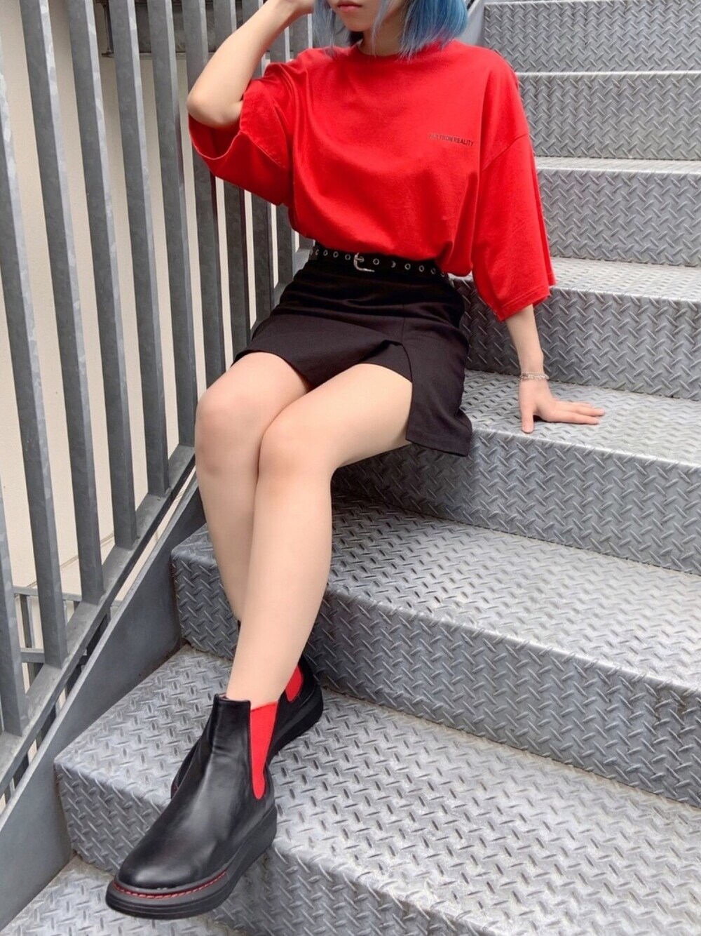 レッド系のTシャツ/カットソー、ブラック系のブーツ、ブラック系のスカートを着用したレディースの夏コーディネートの1枚目の写真