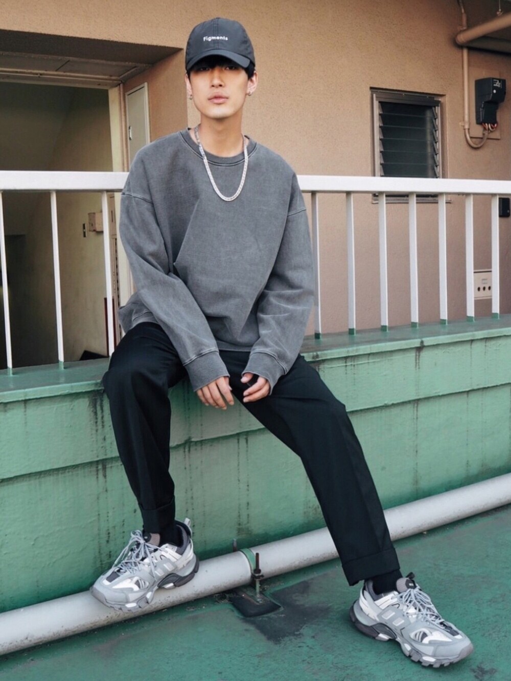 グレー系のスウェット、ブラック系のスラックス、ブラック系のキャップを着用したメンズの秋コーディネートの1枚目の写真