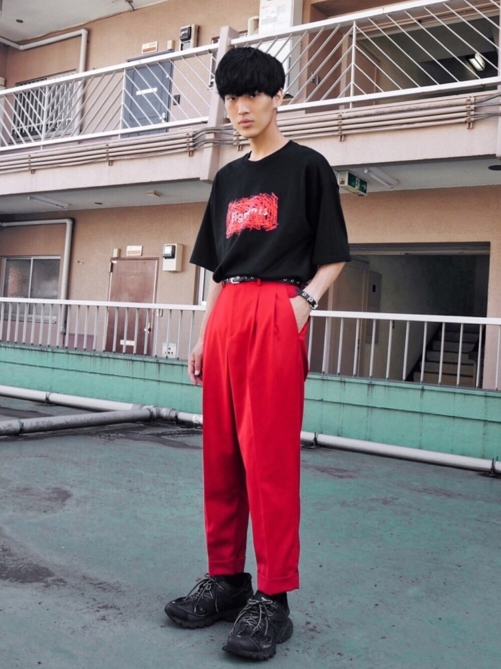 ブラック系のTシャツ/カットソー、レッド系のスラックス、ブラック系のブレスレットを着用したメンズの秋コーディネートの1枚目の写真
