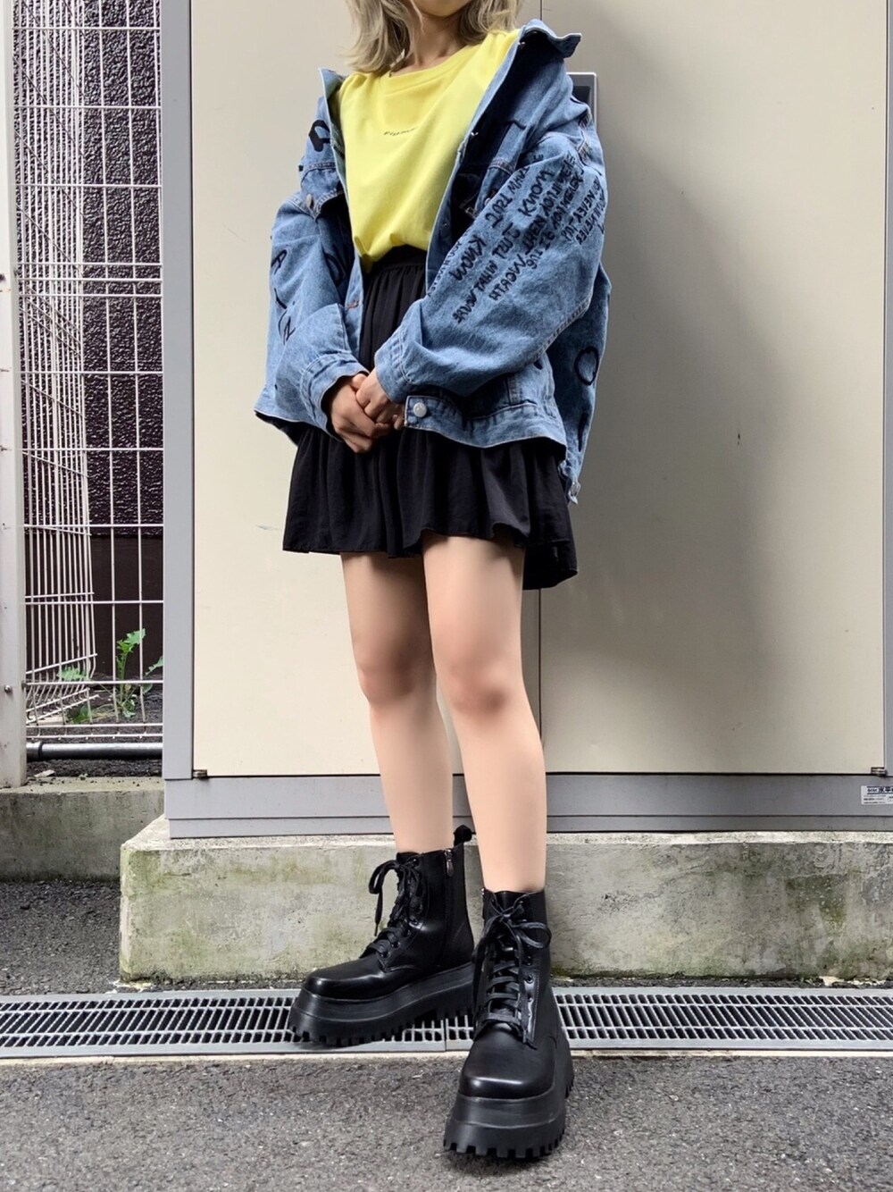 イエロー系のTシャツ/カットソー、ブルー系のデニムジャケット、ブラック系のスカートを着用したレディースの秋コーディネートの1枚目の写真